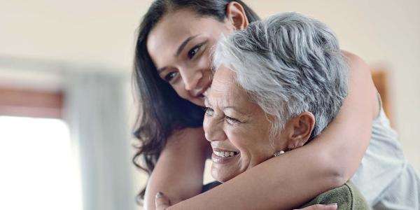 Femme qui enlâce une femme plus âgée qui souris